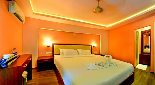 a bedroom with a large bed with an orange wall at GoGo Land Resort & Adventurous Sports in Pūvār