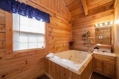 een houten badkamer met een bad en een wastafel bij Sleepin' Inn Holiday home in Sevierville