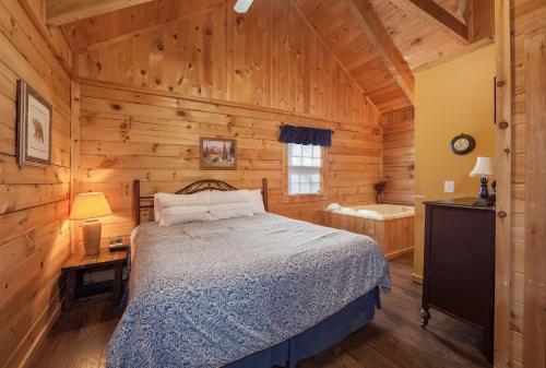 een slaapkamer met een bed in een houten hut bij Sleepin' Inn Holiday home in Sevierville