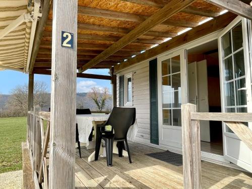 een veranda met een tafel en stoelen erop bij Jura mobile home in Marigny