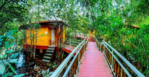 a walkway leading to a house in the forest at GoGo Land Resort & Adventurous Sports in Pūvār