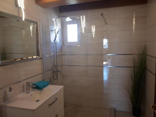 y baño con lavabo y ducha con espejo. en Ferienhaus Magyar, en Lovas