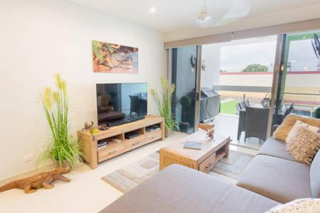 a living room with a couch and a tv at Crocs on Cavenagh in Darwin