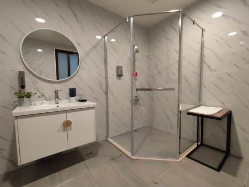 a bathroom with a shower with a sink and a mirror at February Flower B&B in Dongshan