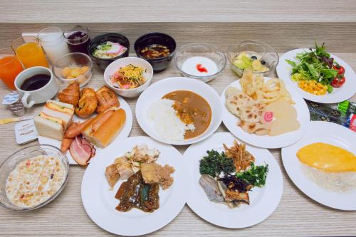 a table topped with plates of food and drinks at Kuretake Inn Premium Meieki minami in Nagoya