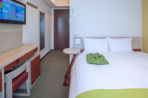 a small room with a bed and a television at Kuretake Inn Premium Meieki minami in Nagoya