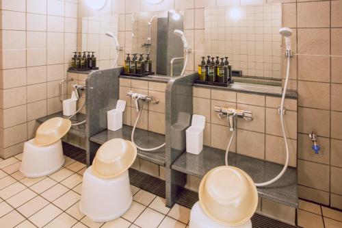 a bathroom with three toilets and a mirror at Kuretake Inn Premium Meieki minami in Nagoya