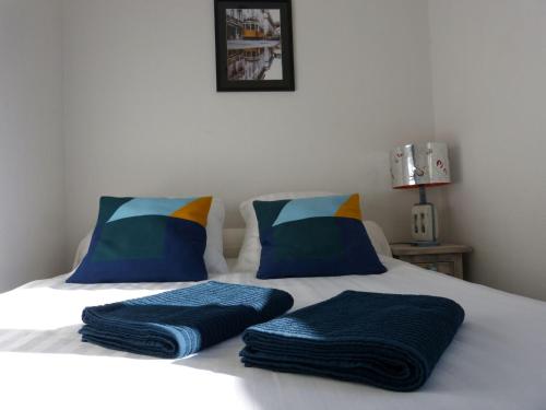 a bed with two pillows on top of it at Appartement Topaze Bourg d'Oisans in Le Bourg-dʼOisans