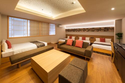 名古屋的住宿－GRAND BASE -Nagoya Chiyokura-，一间带两张床和一张沙发的客厅