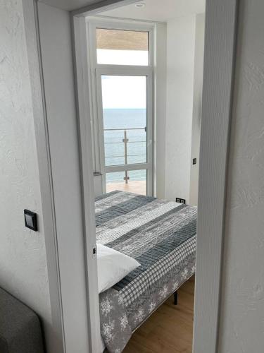 a bedroom with a bed with a view of the ocean at Arcadia apartment & sea terrace in Odesa