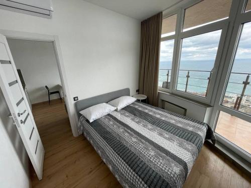 a bedroom with a bed with a view of the ocean at Arcadia apartment & sea terrace in Odesa