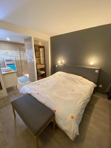 a bedroom with a large bed with a bench in it at Appartement Golf International de la Baule in Saint-André-des-Eaux