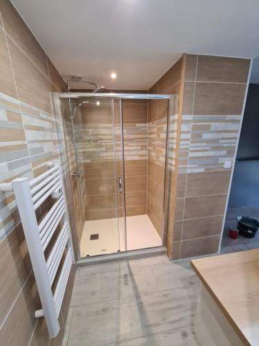 une douche avec une porte vitrée dans une salle de bain dans l'établissement Appartement Golf International de la Baule, Saint Denac, Saint André des Eaux, à Saint-André-des-Eaux