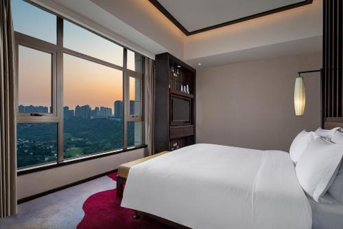 a bedroom with a white bed and a large window at Crowne Plaza Chongqing New North Zone by IHG in Chongqing