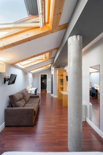a living room with a couch and a pole at Hotel El Coloquio in Valladolid