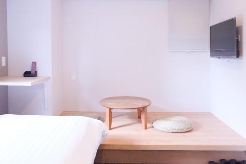 a small stool sitting on a wooden table in a bedroom at The Light Inn Tokyo in Tokyo