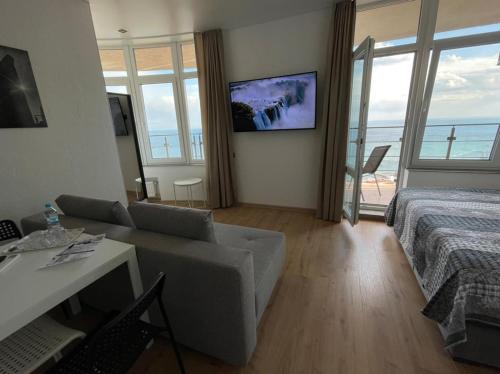 a living room with a couch and a bed and a television at Arcadia apartment & sea terrace in Odesa