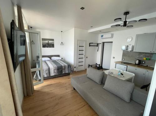 a living room with a couch and a bed at Arcadia apartment & sea terrace in Odesa