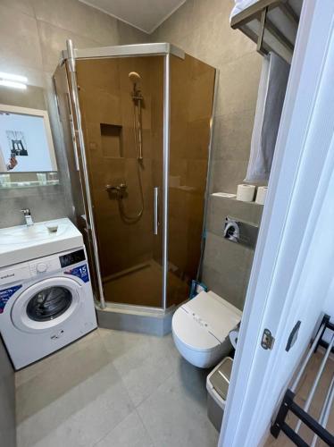 a bathroom with a shower and a washing machine at Arcadia apartment & sea terrace in Odesa