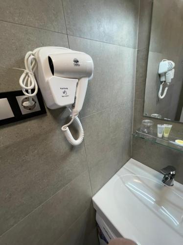 a hair dryer on a wall next to a sink at Arcadia apartment & sea terrace in Odesa