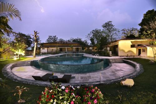 a swimming pool in the yard of a house at Jungle Villa Resort - Near Chitwan National Park in Chitwan