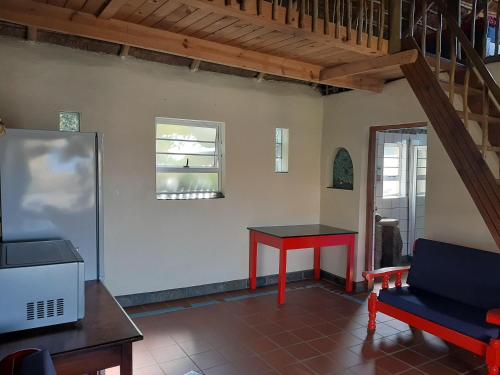 een woonkamer met een rode tafel en een raam bij Coffee Shack Adventure Backpackers & Self-Catering in Coffee Bay