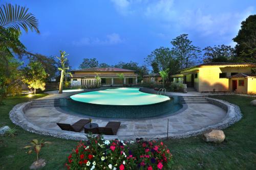 a large swimming pool in a yard at night at Jungle Villa Resort - Near Chitwan National Park in Chitwan