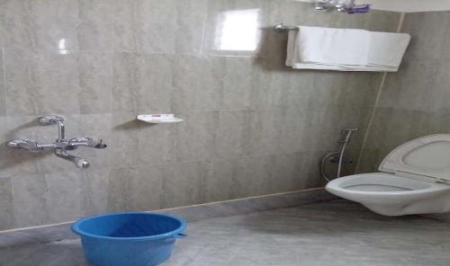 bagno con servizi igienici e secchio blu di Darjeeling Tourist Lodge a Darjeeling
