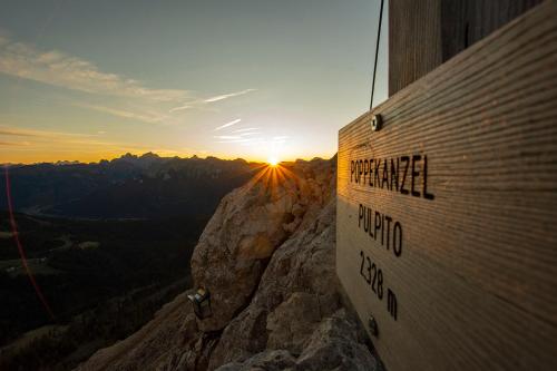 a sign on the side of a mountain at sunset at Moseralm Dolomiti Spa Resort in Nova Levante