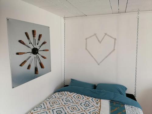 a bedroom with a clock on the wall and a bed at Best Price #2 "L'ATELIER" x5 people in Orchamps-Vennes