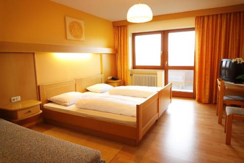 a bedroom with a bed and a television in it at Landgasthof Baumgartner in Dingolfing