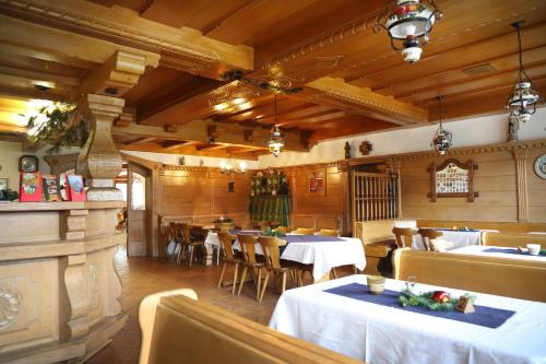 a restaurant with white tables and chairs and wooden walls at Landgasthof Baumgartner in Dingolfing