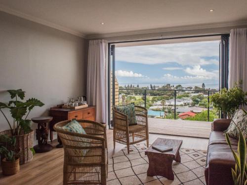 a living room with a couch and a large window at Ridge House in Hermanus