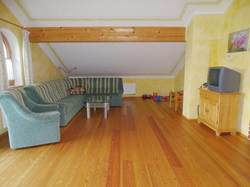 a living room with a couch and a tv at Sunnhof in Oberhofen am Irrsee