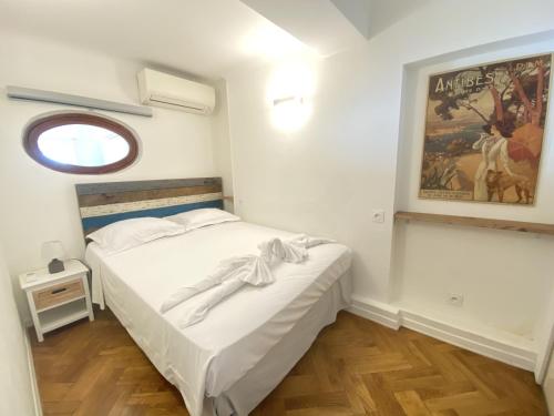 une petite chambre avec un lit blanc et une fenêtre dans l'établissement PROMENADE HOLIDAY - OLD TOWN PANORAMIC, à Nice