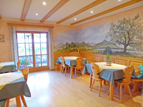 a restaurant with tables and chairs and a painting on the wall at Sunnhof in Oberhofen am Irrsee