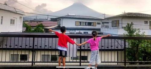 a boy and a girl standing on a fence at Guest house En in Fujiyoshida