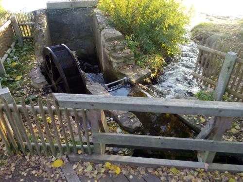 a fence next to a stream of water with a object at Gasthof Russenbräu in Tiefenbach