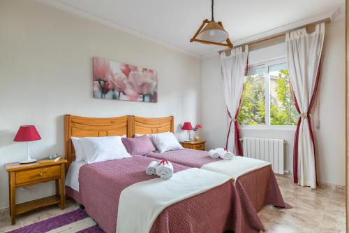 a bedroom with two beds and a window at El Jardín de Alameda in Alameda del Valle