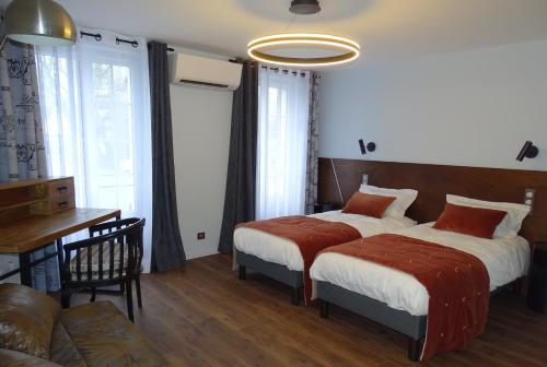 1 dormitorio con 2 camas, mesa y sofá en Auberge de la garenne, en Saint-Rémy-lʼHonoré