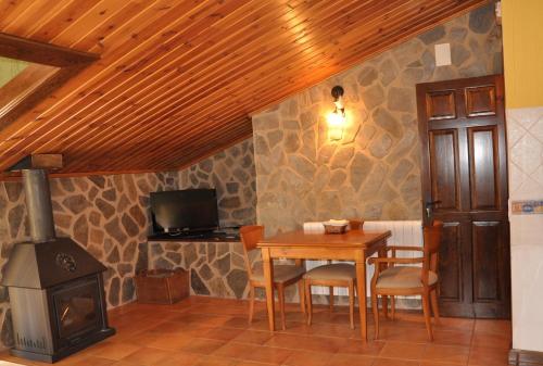 ein Esszimmer mit einem Tisch und einem Holzofen in der Unterkunft Apartamento Los Callejones in Las Majadas