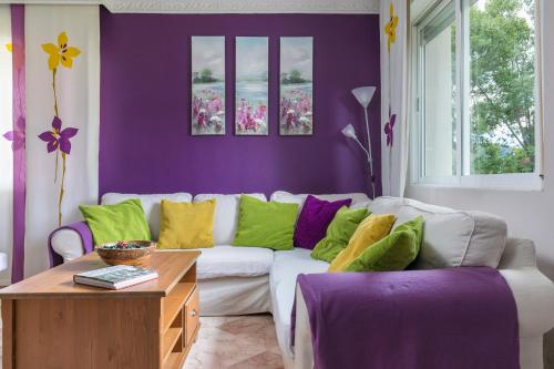 a living room with a white couch with colorful pillows at El Jardín de Alameda in Alameda del Valle