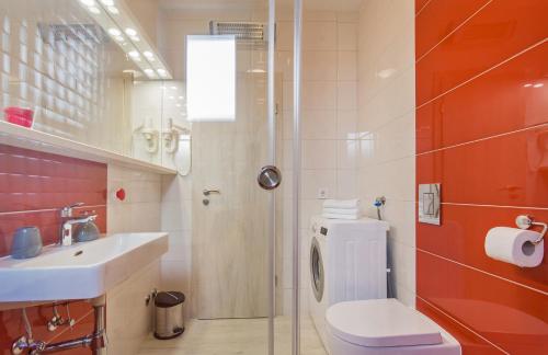uma casa de banho com um WC, um lavatório e um chuveiro em Apartments More em Sobra