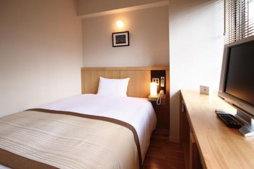 a bedroom with a bed and a flat screen tv at Sutton Place Hotel Ueno in Tokyo