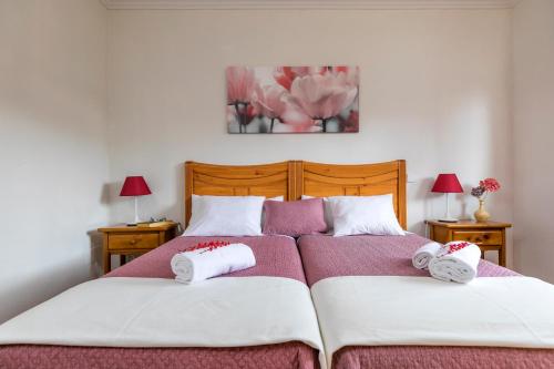 a bedroom with two beds with towels on them at El Jardín de Alameda in Alameda del Valle