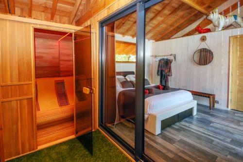 Cette chambre comprend un lit et une baignoire. dans l'établissement La Canopee, à Cahuzac-sur-Vère