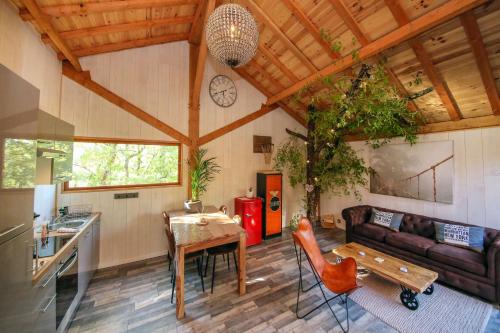 une cuisine et un salon avec un canapé et une table dans l'établissement La Canopee, à Cahuzac-sur-Vère