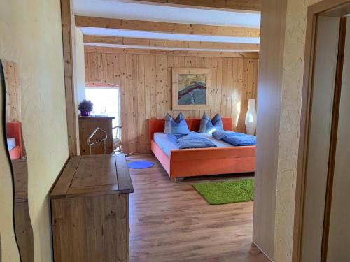 una sala de estar con un sofá naranja en una habitación en Lindenhof, en Hecklingen