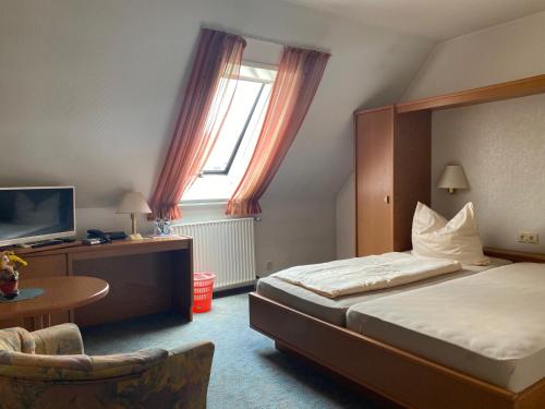 a hotel room with a bed and a television at Meyers Gasthof in Bothel