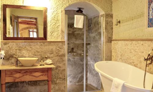 a bathroom with a shower and a tub and a sink at Seki Cave Suites in Goreme